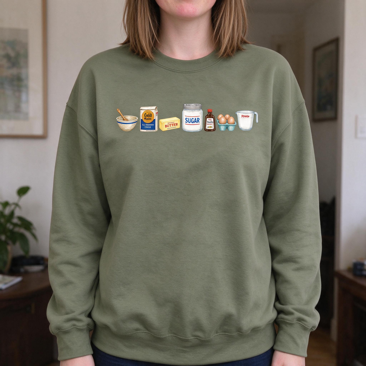 Model wearing the Baking Ingredients sweatshirt in Military Green, lifestyle image 1