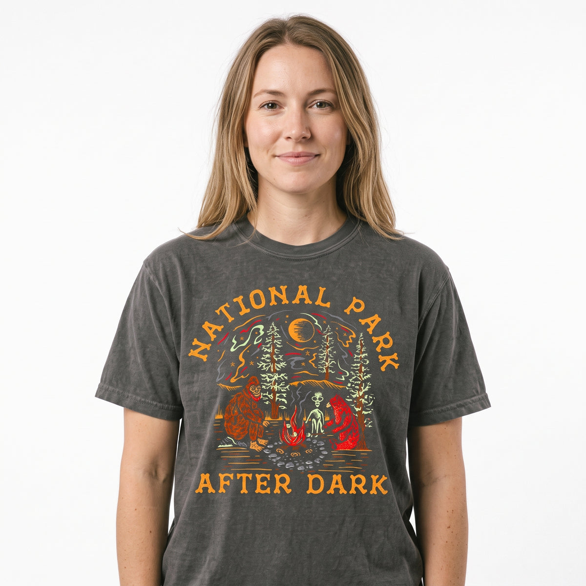 Model wearing the Bigfoot Bear Alien Campfire comfort colors tee in Pepper, cover image 1