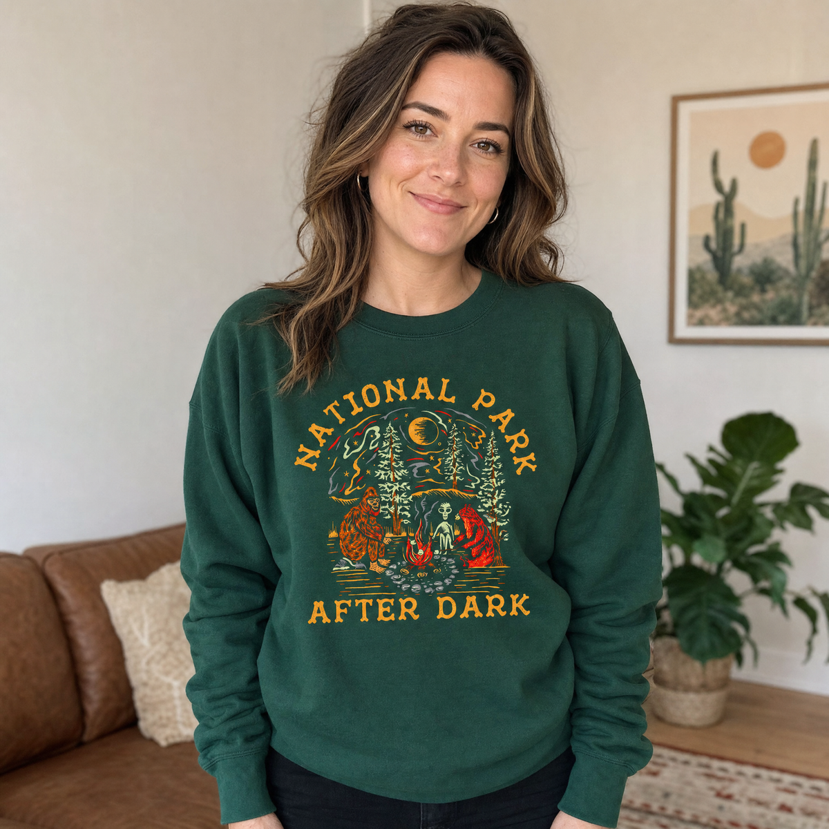 Model wearing the Bigfoot Bear Alien Campfire sweatshirt in Forest Green, lifestyle image 1
