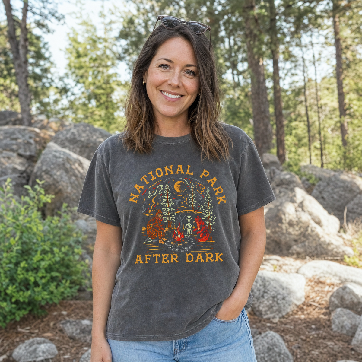 Model wearing the Bigfoot Bear Alien Campfire comfort colors tee in Pepper, lifestyle image 1