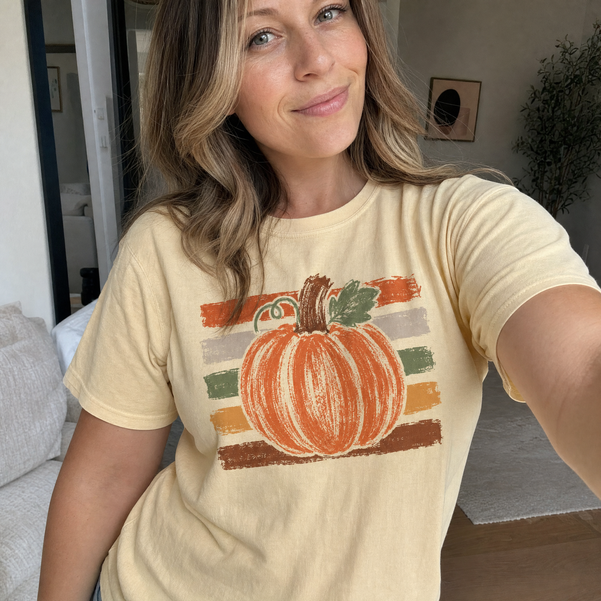 Model wearing the Brushstroke Pumpkin comfort colors tee in Butter