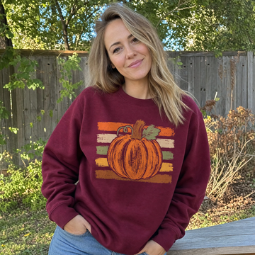 Model wearing the Brushstroke Pumpkin sweatshirt in Maroon