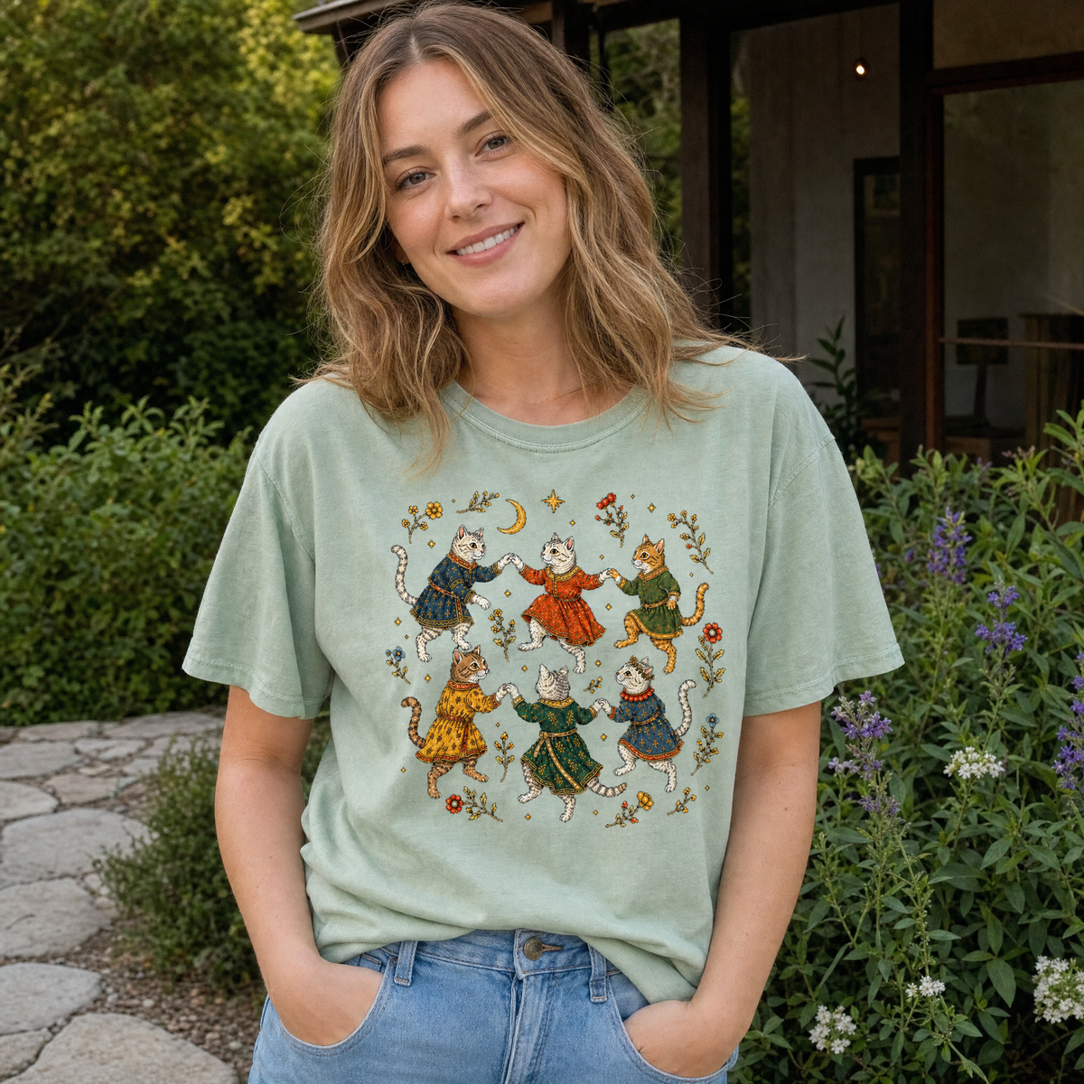 Model wearing the Dancing Medieval Cats comfort colors tee in Bay