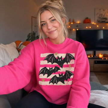 Model wearing the Distressed Bats sweatshirt in Heliconia