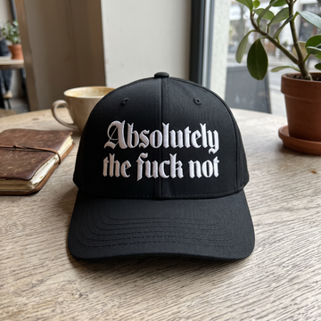 Absolutely The F*** Not embroidered hat in Black resting on a flat surface