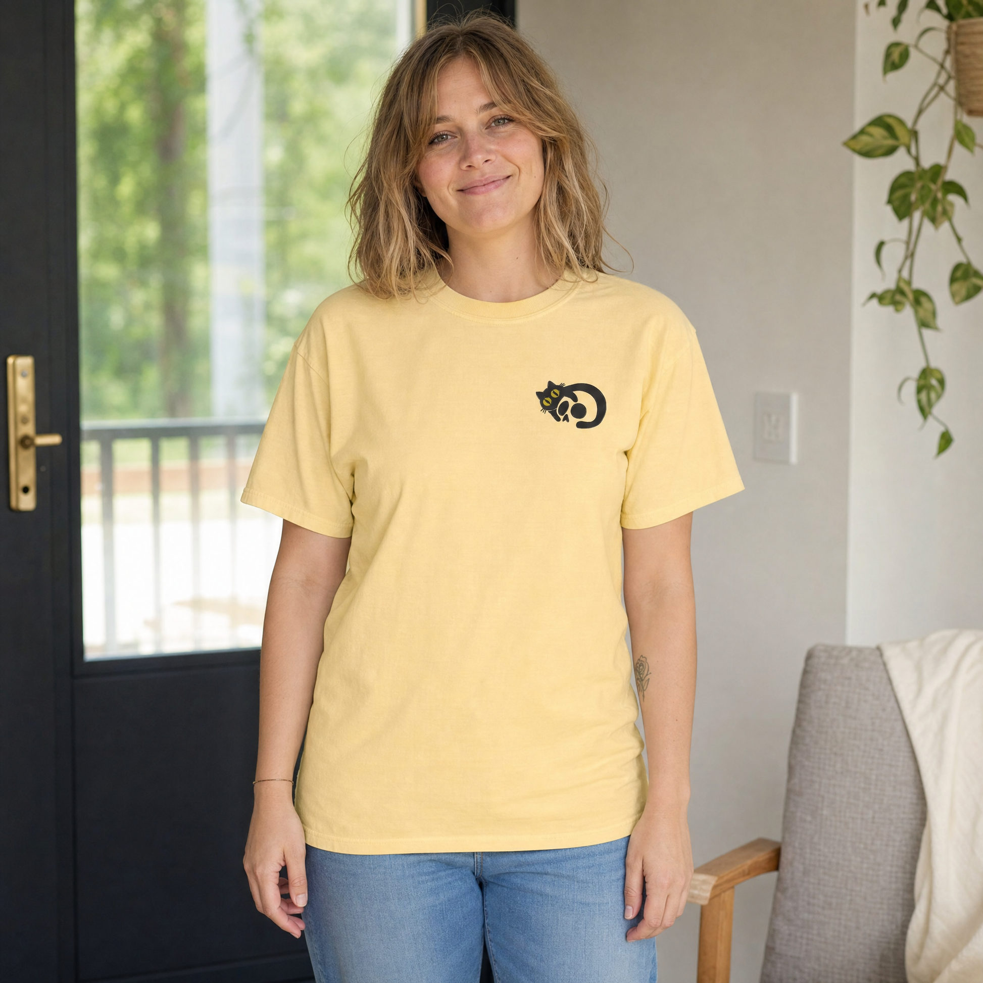 Model wearing the Black Cat Skull comfort colors tee in Butter, lifestyle image 1