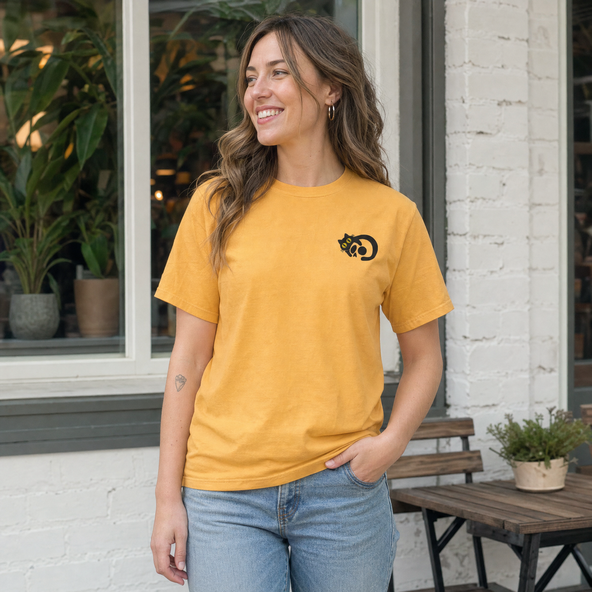 Model wearing the Black Cat Skull comfort colors tee in Mustard, lifestyle image 1