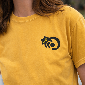 Model wearing the Black Cat Skull comfort colors tee in Mustard, lifestyle image 2