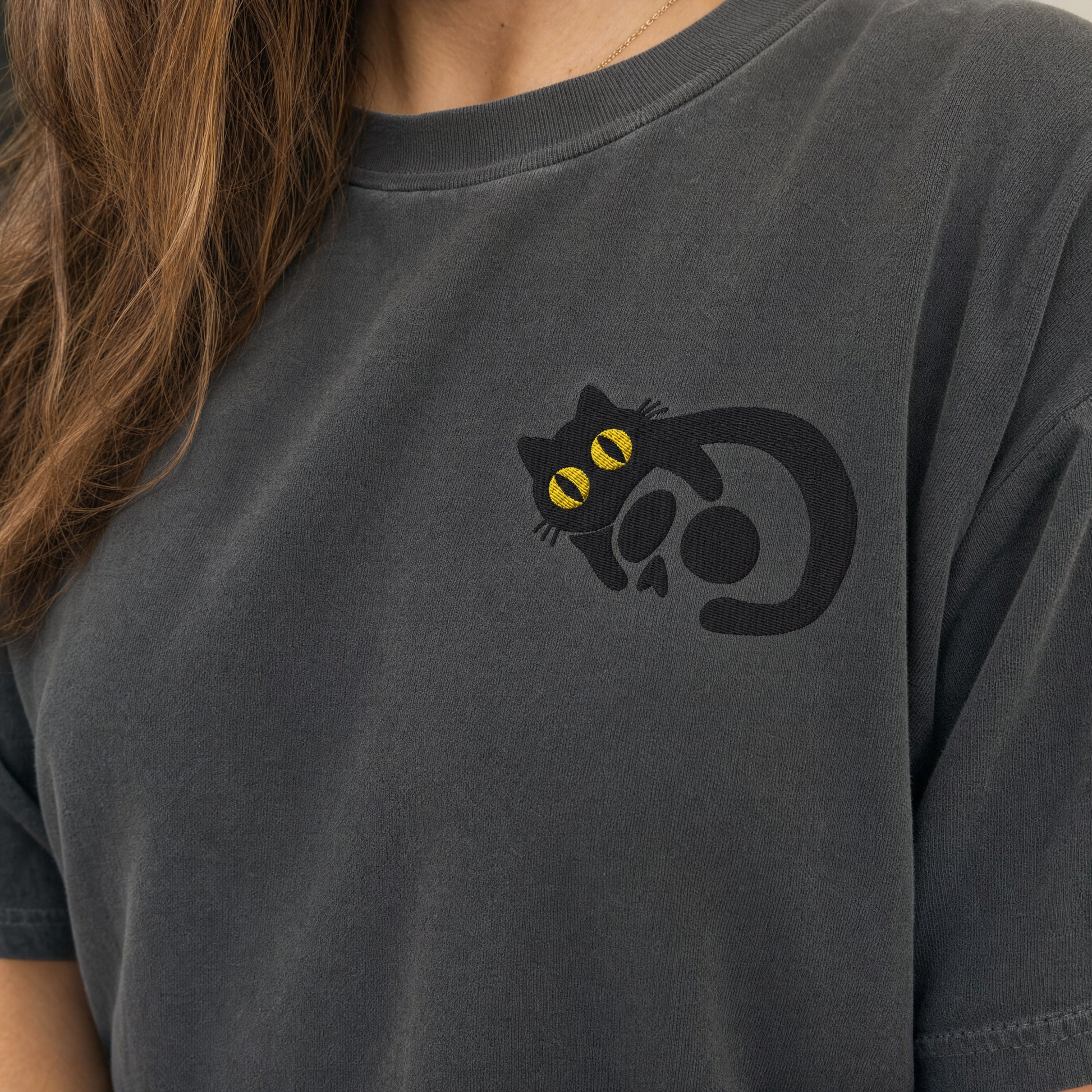 Model wearing the Black Cat Skull comfort colors tee in Pepper, lifestyle image 2
