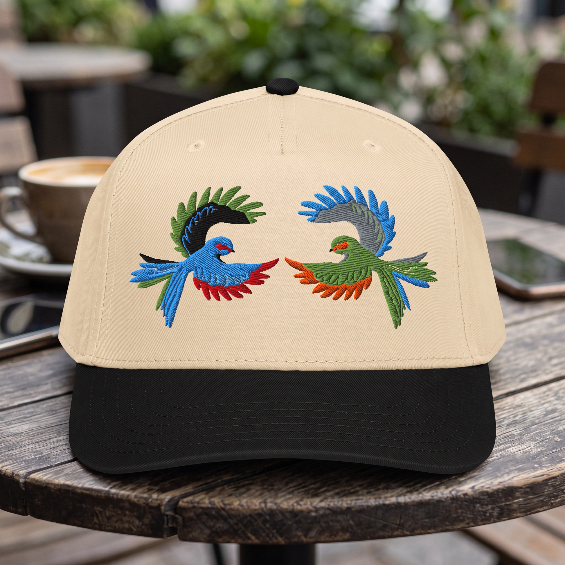 Colorful Tropical Bird embroidered hat in Black/natural resting on a flat surface