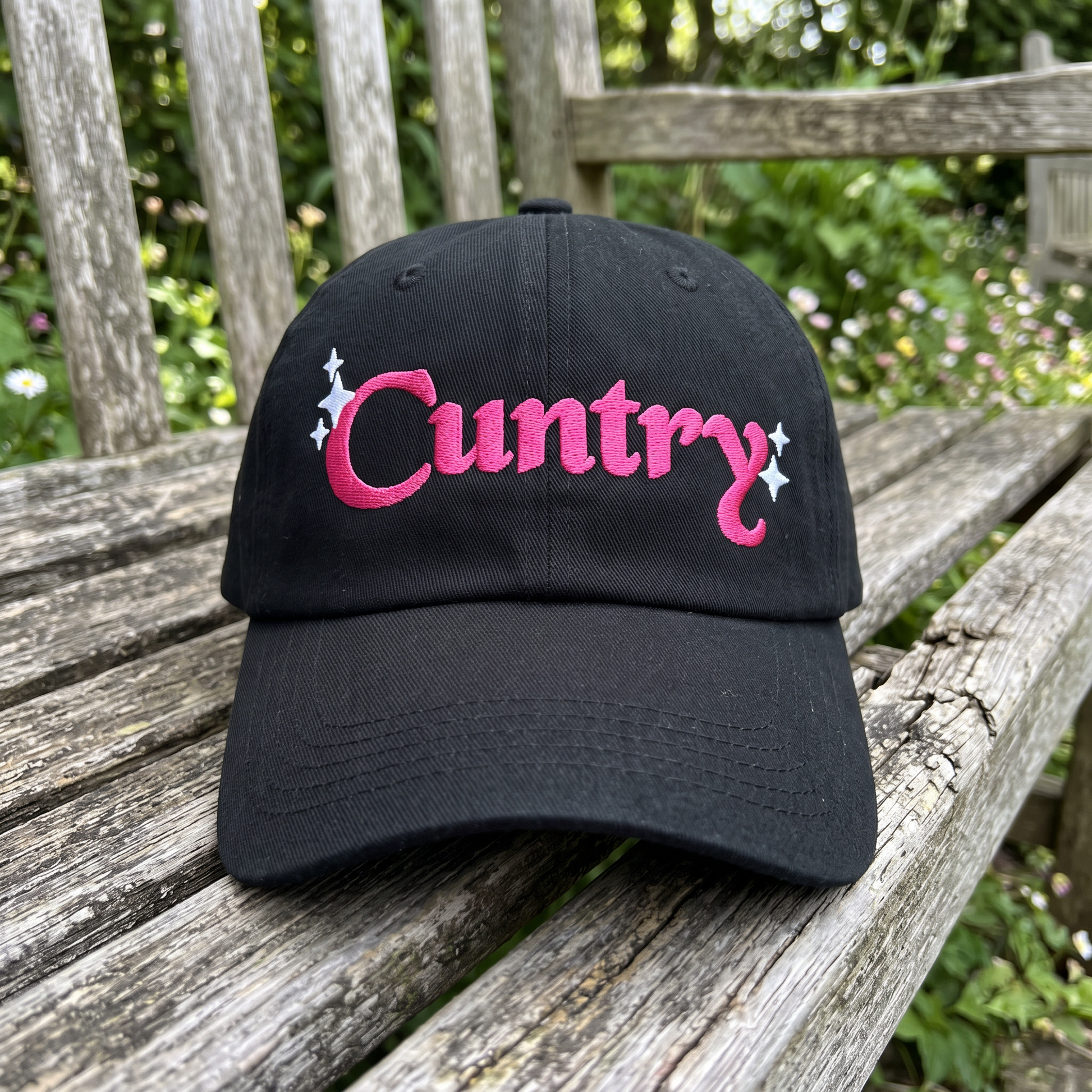 Country Word Art embroidered hat in Black resting on a flat surface, lifestyle image 1