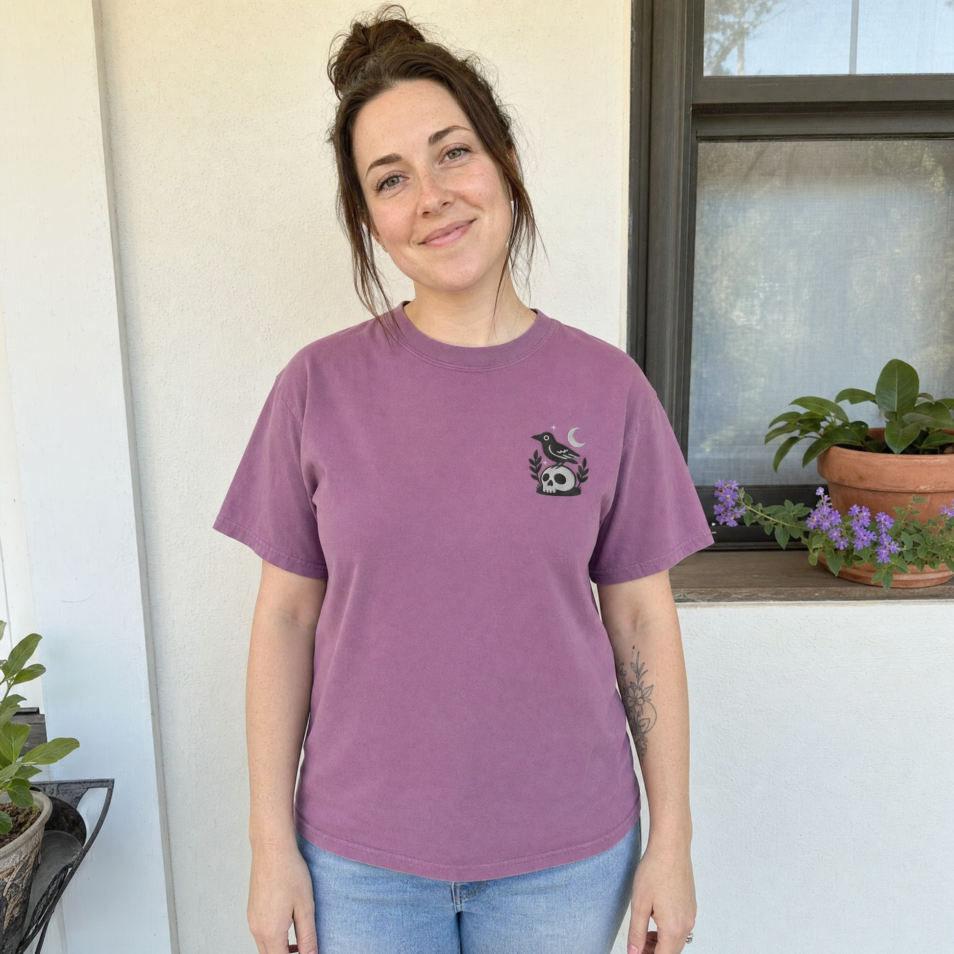 Model wearing the Crow on Skull comfort colors tee in Berry, lifestyle image 1