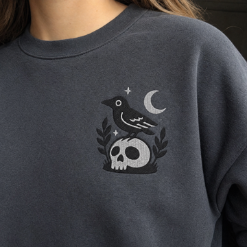 Model wearing the Crow on Skull sweatshirt in Dark Heather, lifestyle image 2