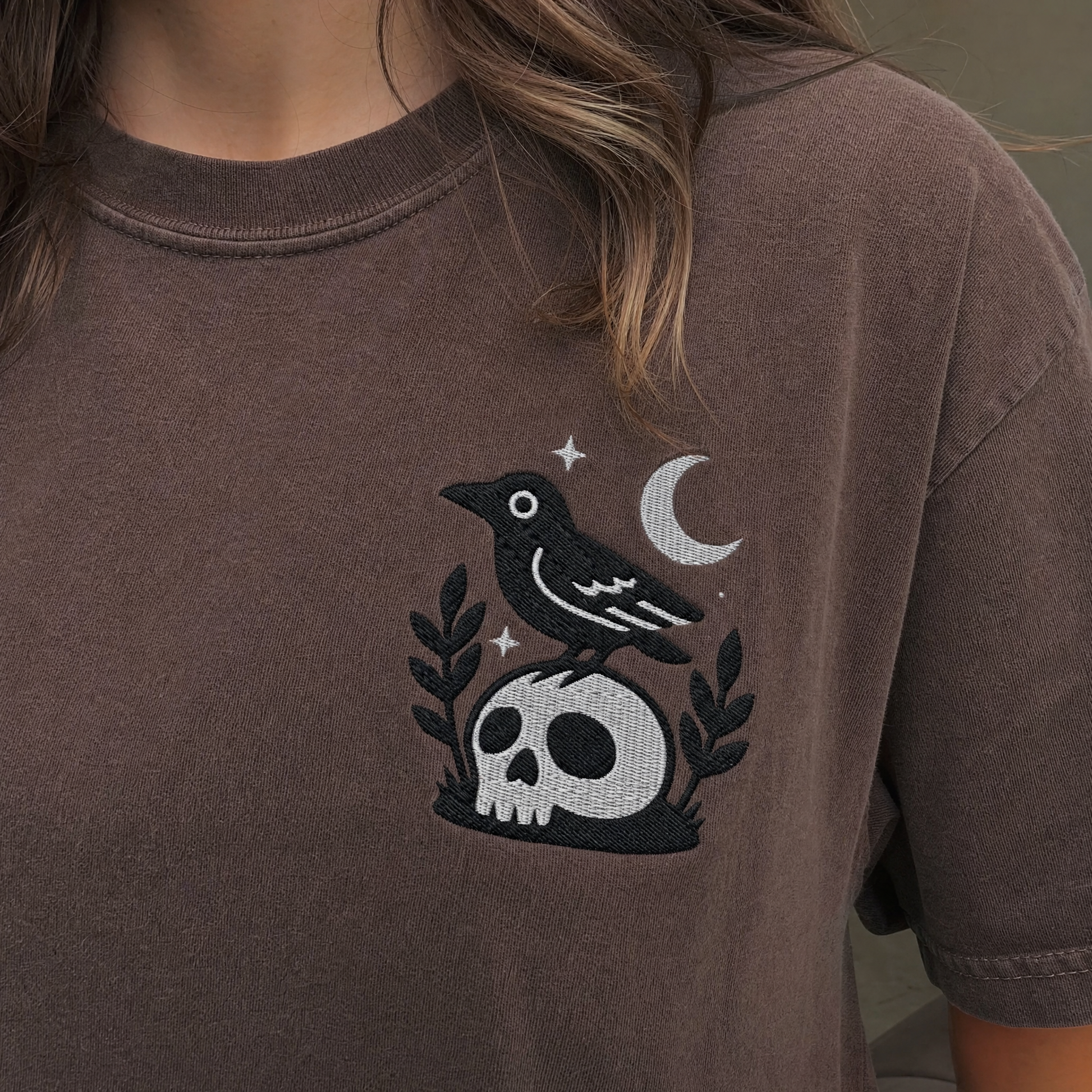 Model wearing the Crow on Skull comfort colors tee in Espresso, lifestyle image 1