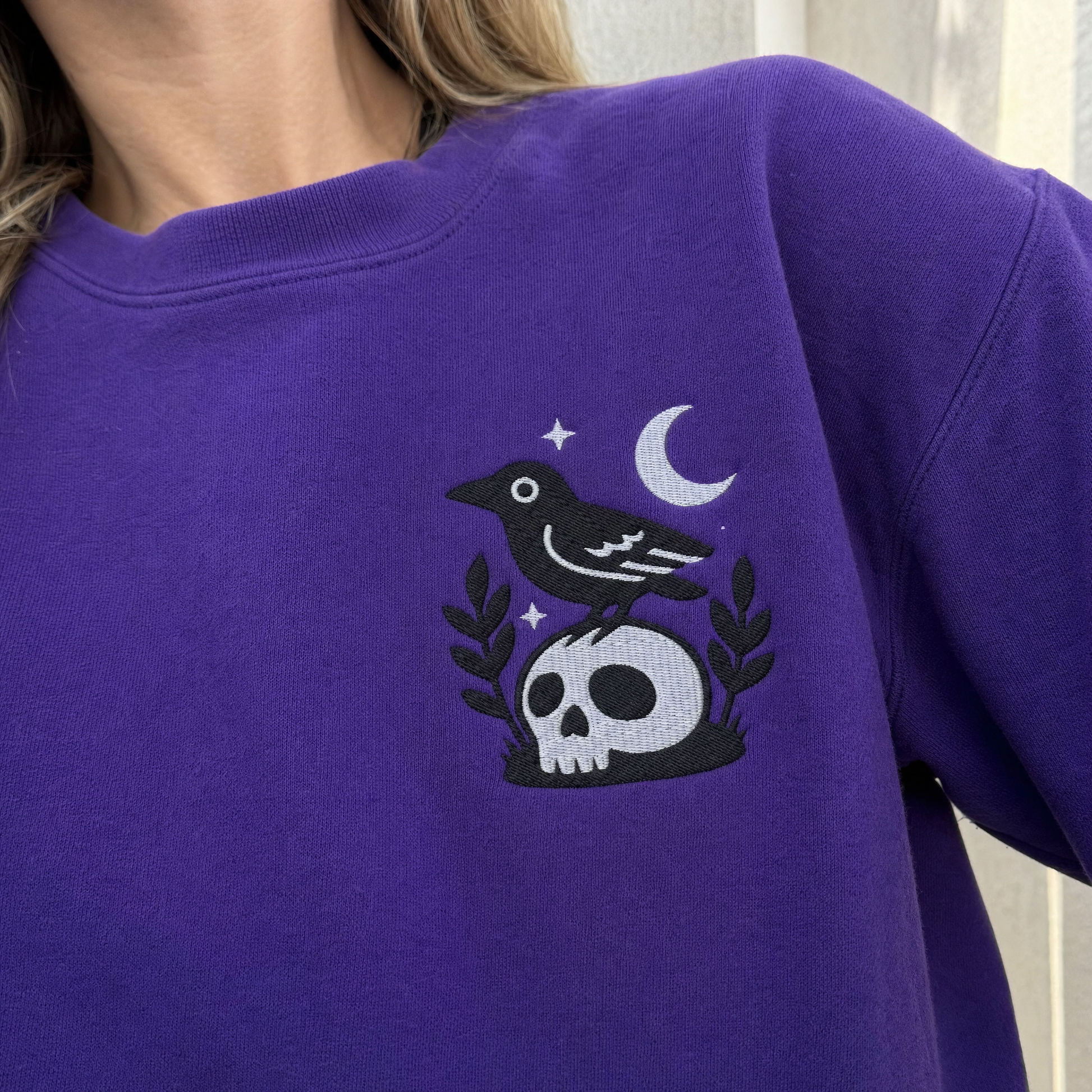 Model wearing the Crow on Skull sweatshirt in Purple, lifestyle image 2