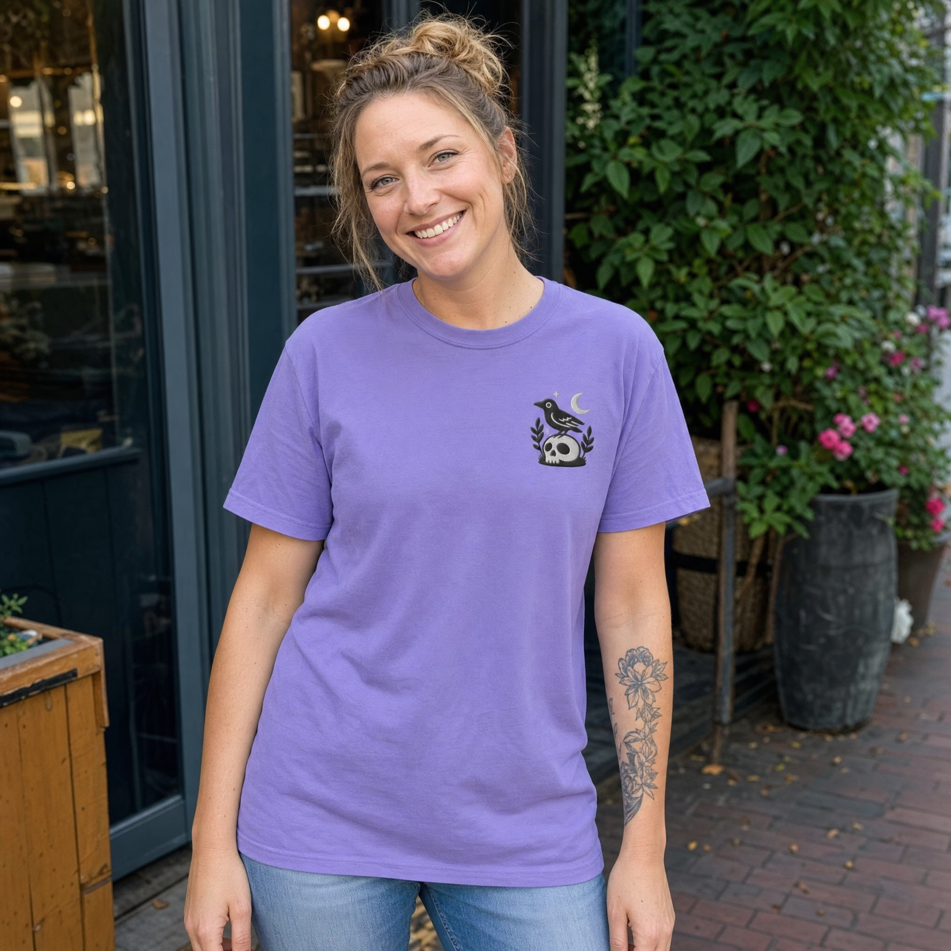 Model wearing the Crow on Skull comfort colors tee in Violet, lifestyle image 1