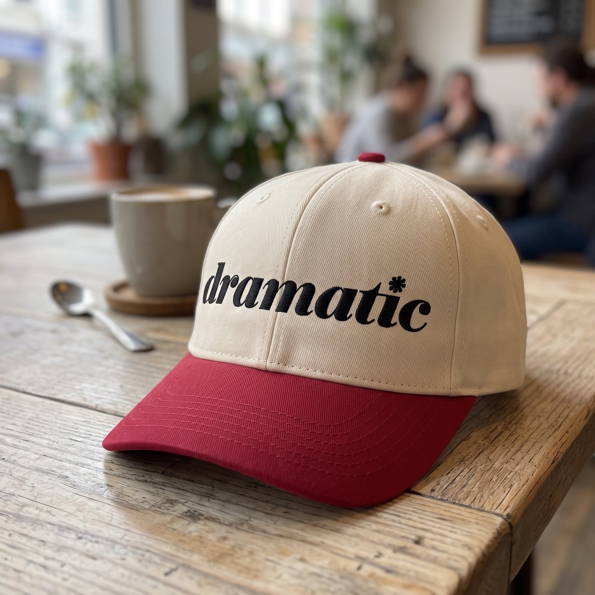 Dramatic Text embroidered hat in Red/natural resting on a flat surface