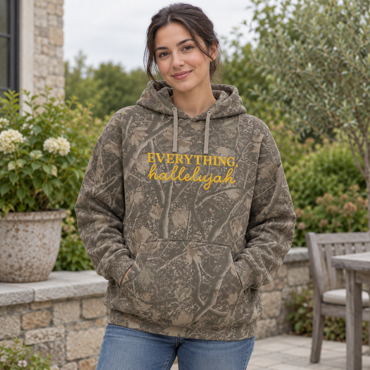 Model wearing the Everything Hallelujah heavyweight hoodie in Light Tree Camo, lifestyle image 1
