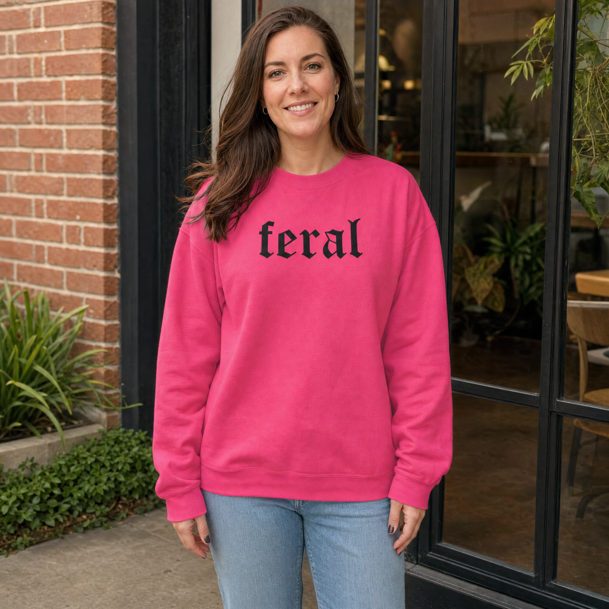 Model wearing the Feral sweatshirt in Heliconia, lifestyle image 1