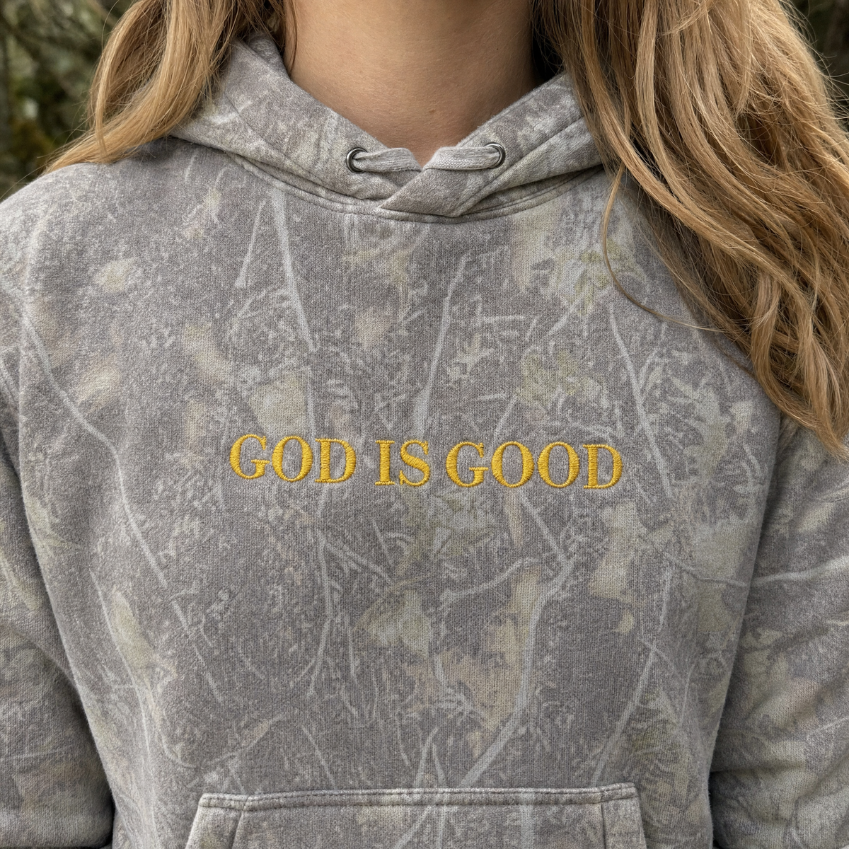 Model wearing the God Is Good heavyweight hoodie in Deadwood Tree Camo, lifestyle image 2