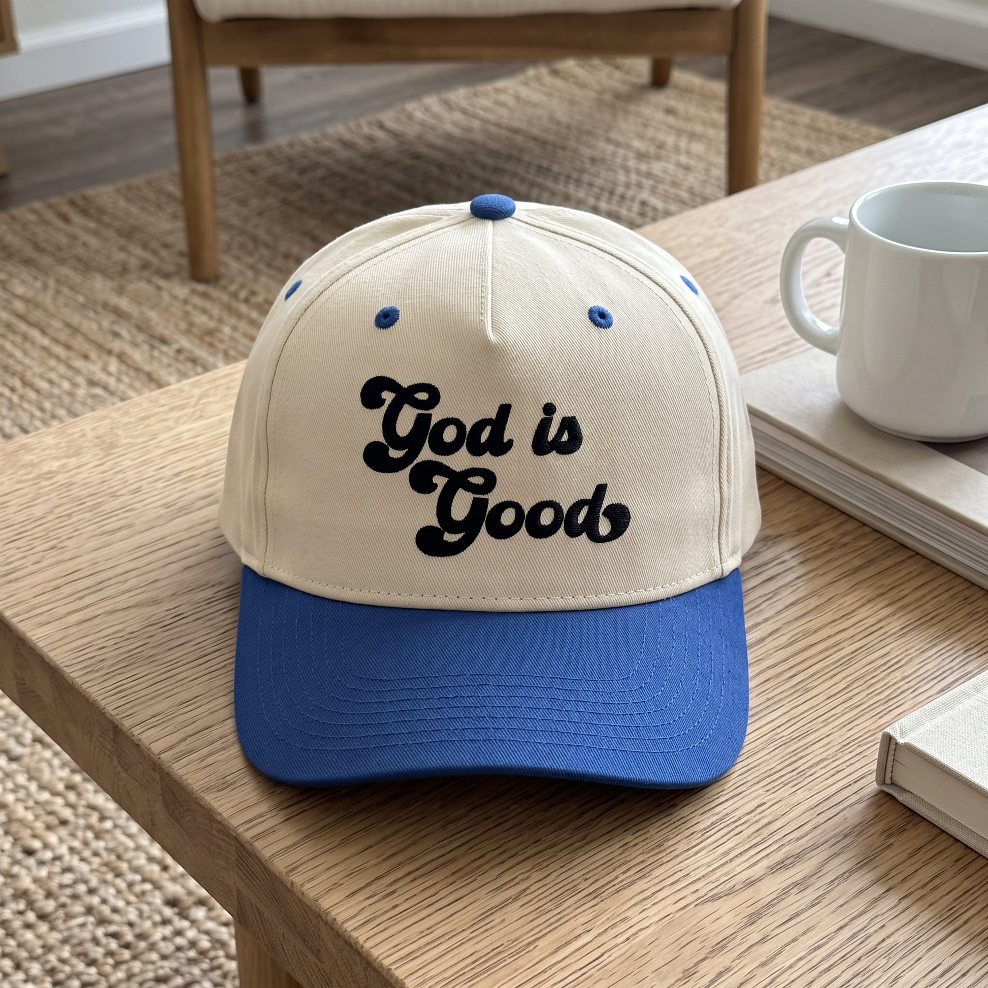 God is Good embroidered hat in Royal/natural resting on a flat surface