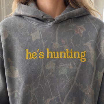 Model wearing the He's Hunting heavyweight hoodie in Darkwood Tree Camo, lifestyle image 1