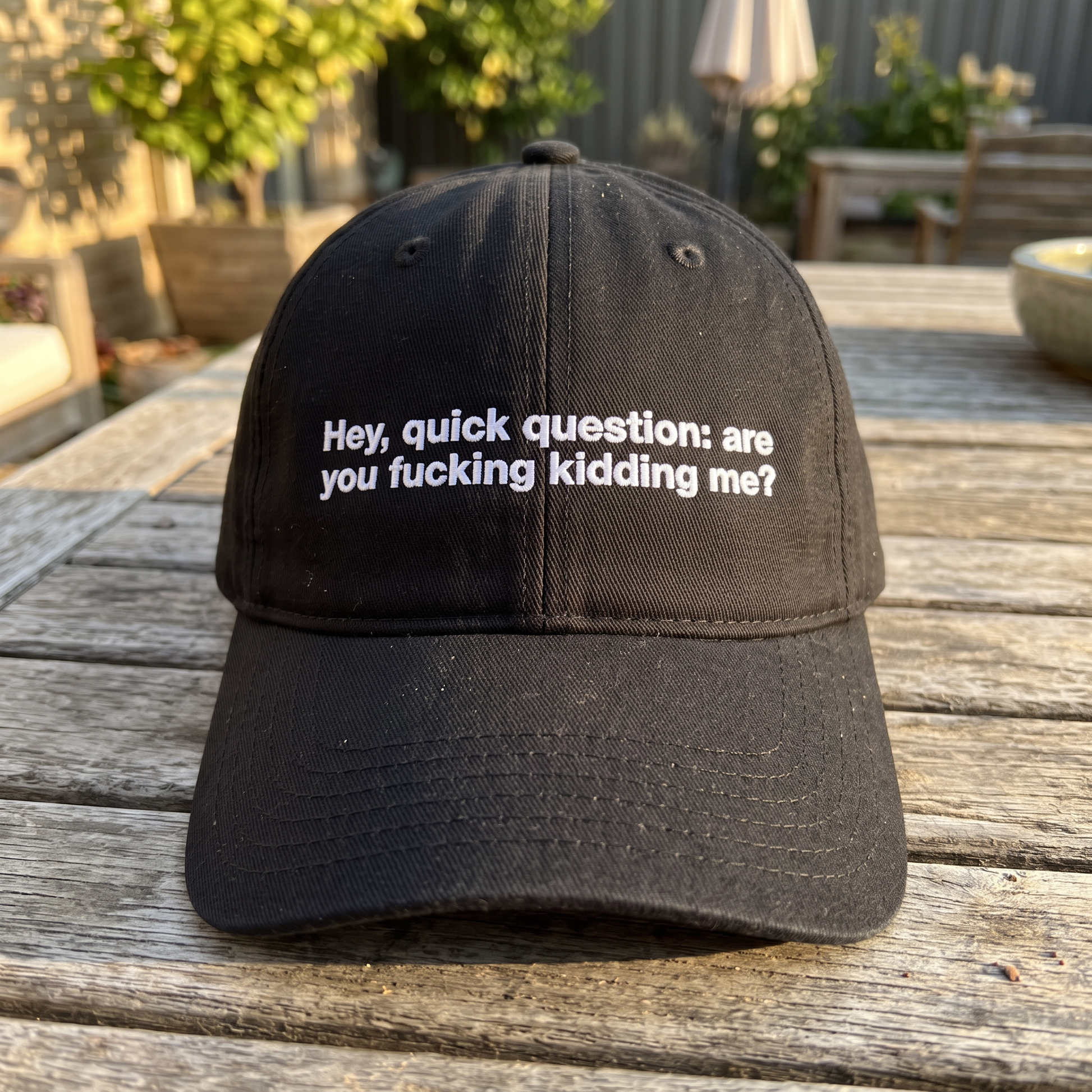 Hey Quick Question embroidered hat in Black resting on a flat surface, lifestyle image 2