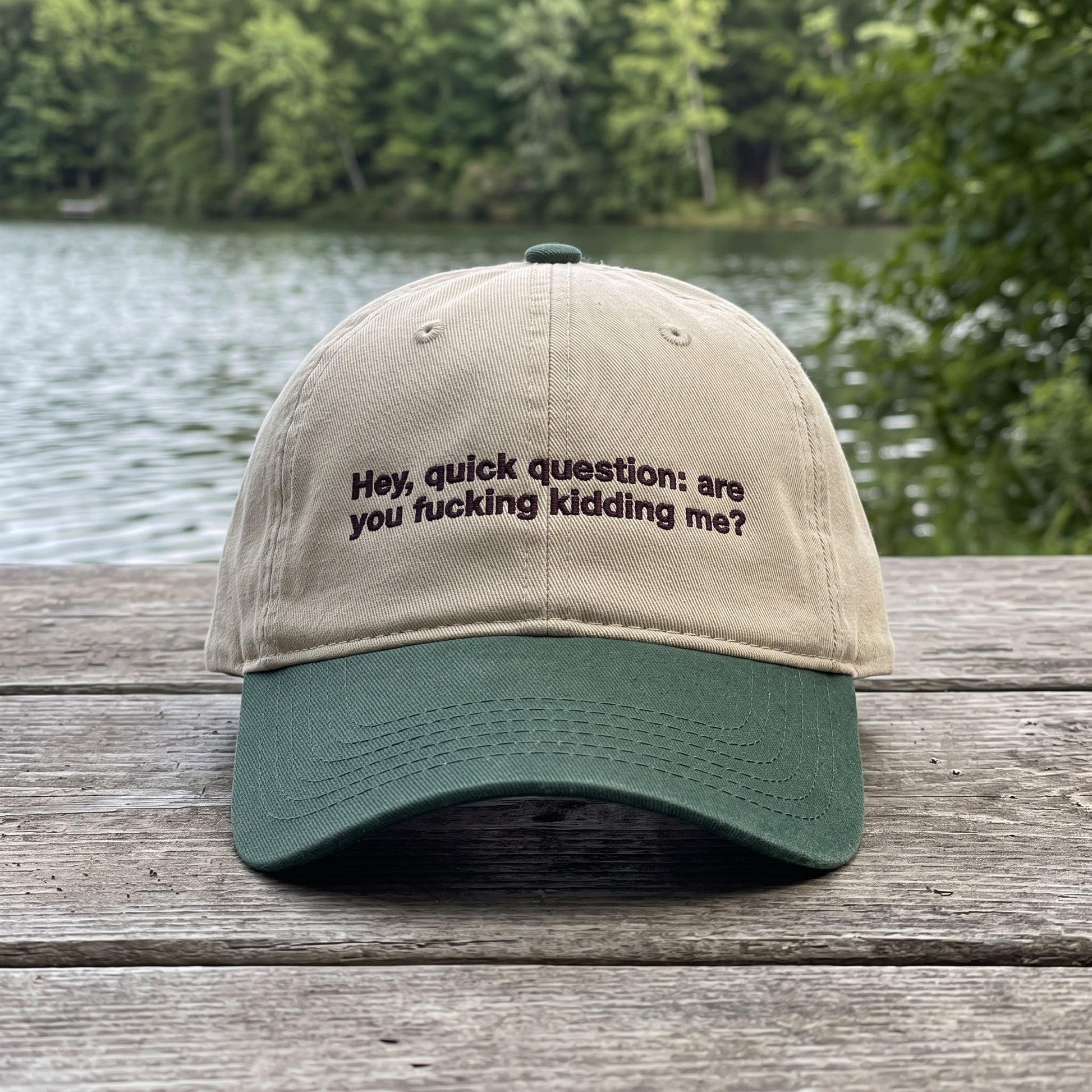 Hey Quick Question embroidered hat in Dark Green/khaki resting on a flat surface, lifestyle image 1