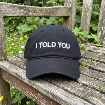 I Told You embroidered hat in Black resting on a flat surface, lifestyle image 1