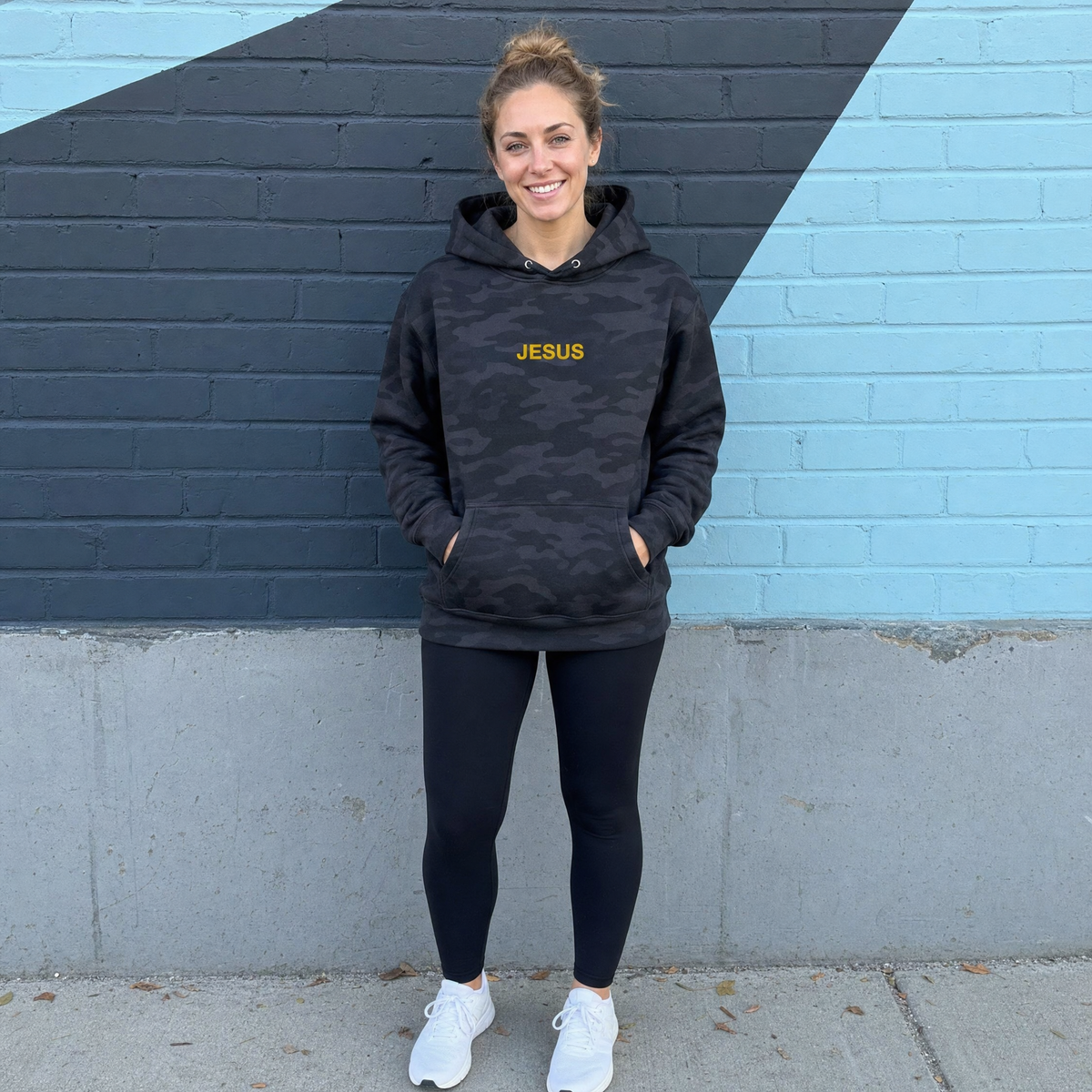Model wearing the JESUS Text heavyweight hoodie in Black Camo, cover image 1
