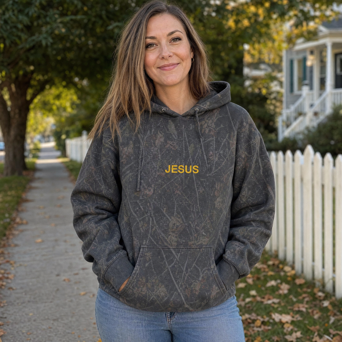 Model wearing the JESUS Text heavyweight hoodie in Dark Tree Camo, lifestyle image 1