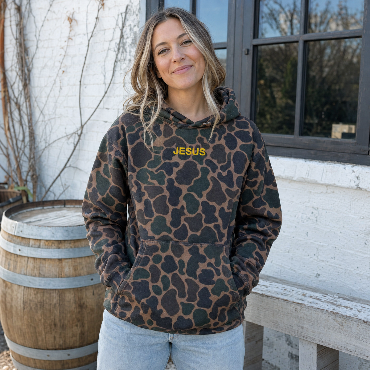Model wearing the JESUS Text heavyweight hoodie in Duck Camo, lifestyle image 1
