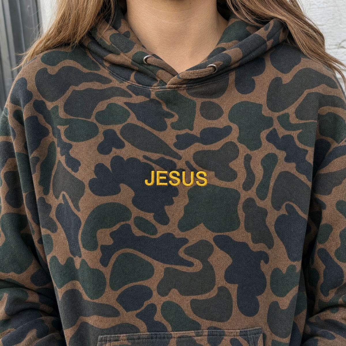Model wearing the JESUS Text heavyweight hoodie in Duck Camo, lifestyle image 2
