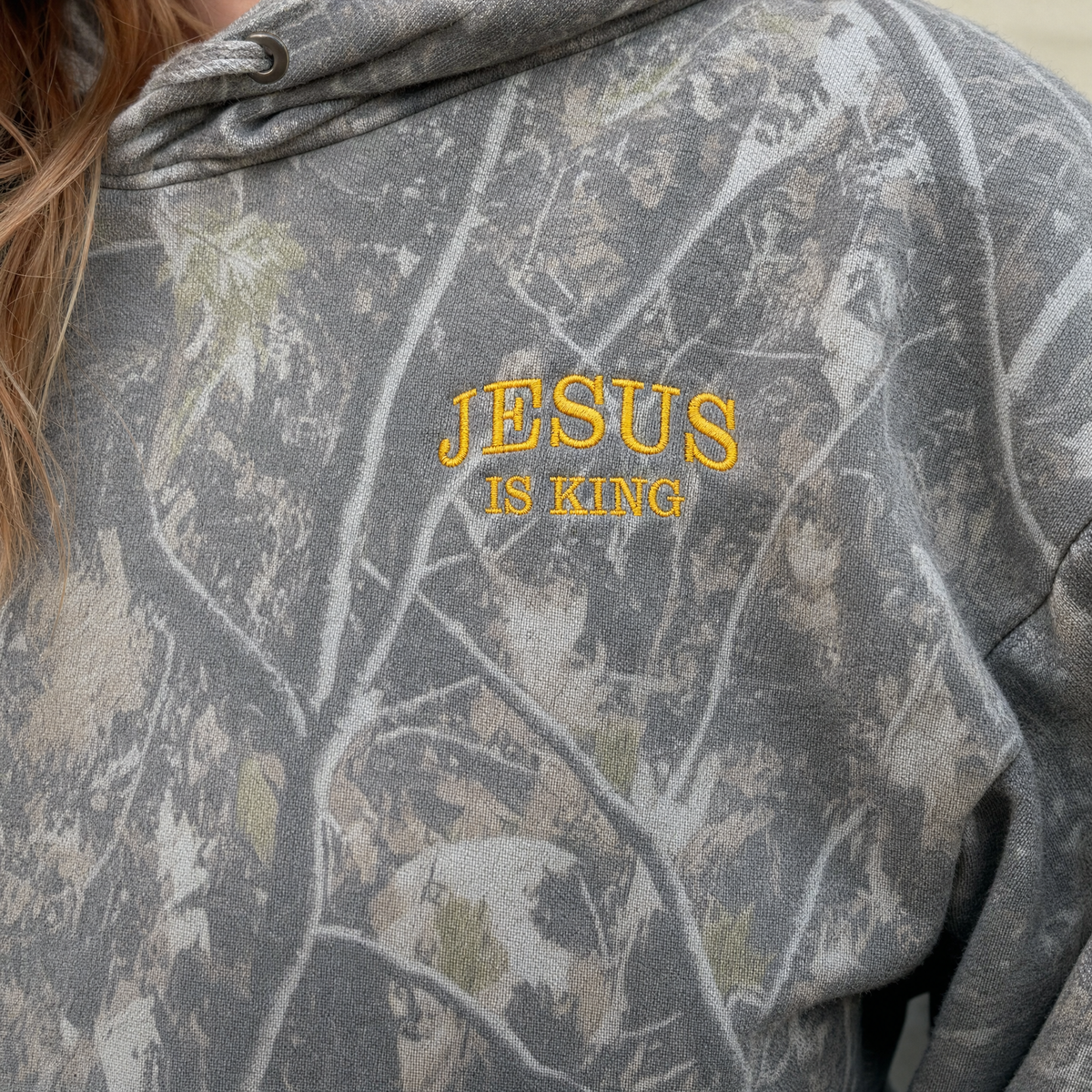 Model wearing the Jesus Is King heavyweight hoodie in Deadwood Tree Camo, lifestyle image 2