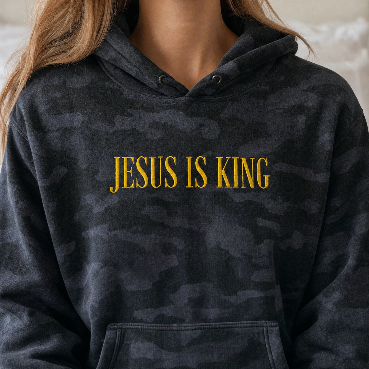 Model wearing the Jesus Is King heavyweight hoodie in Black Camo, lifestyle image 2