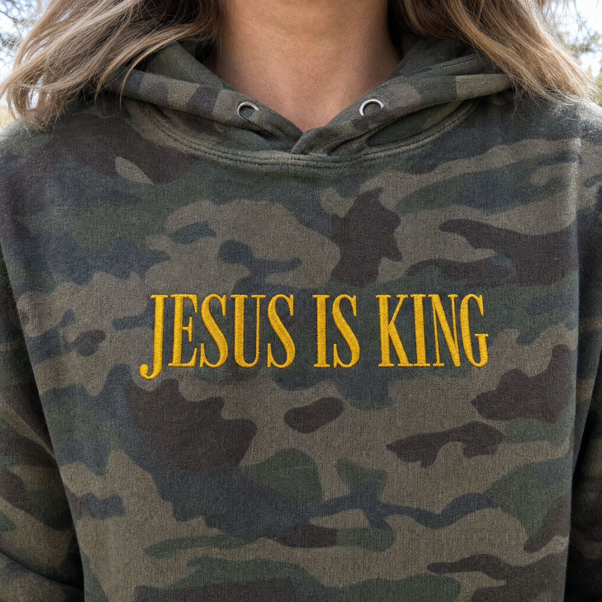 Model wearing the Jesus Is King heavyweight hoodie in Green Camo, lifestyle image 2