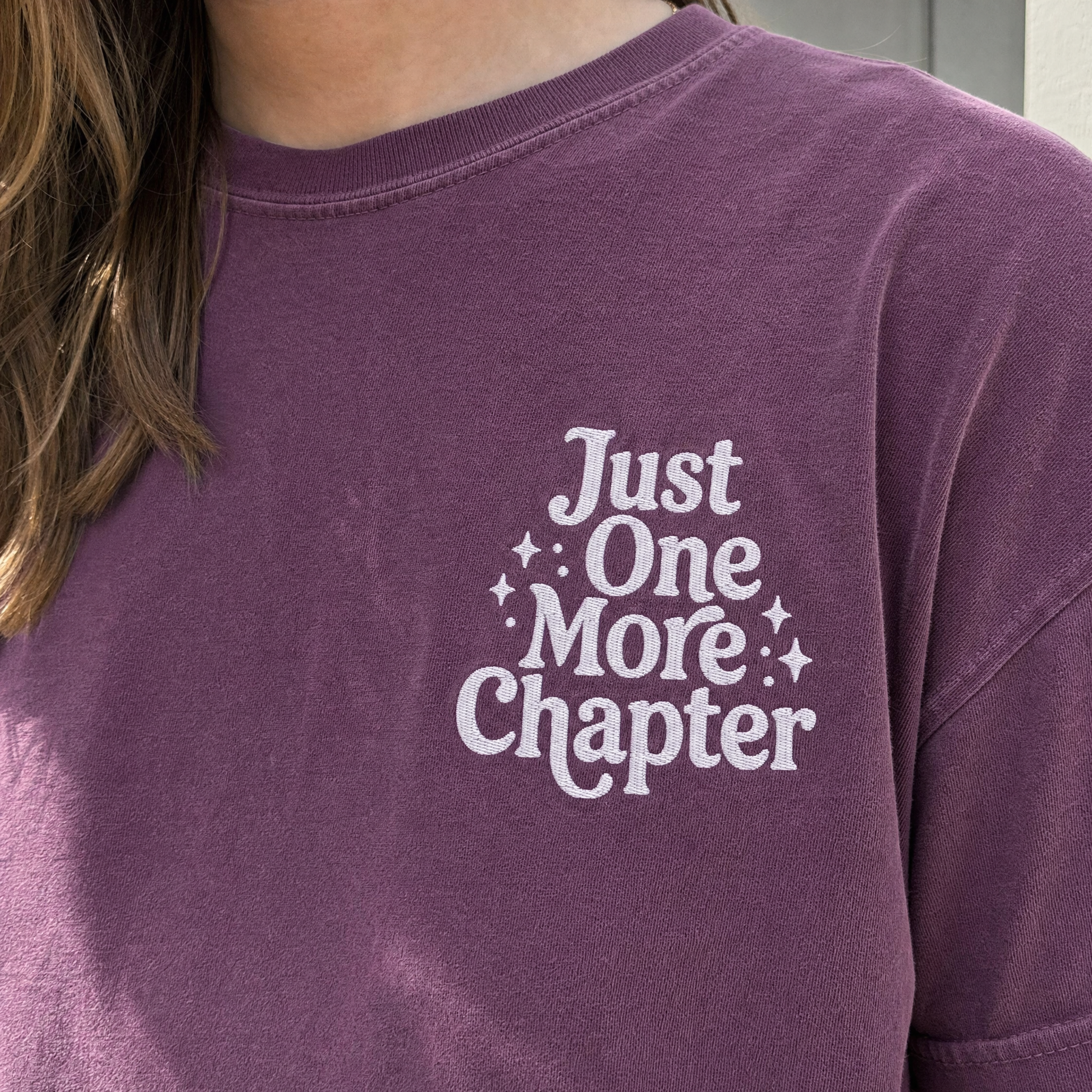 Model wearing the Just One More Chapter comfort colors tee in Berry, lifestyle image 2