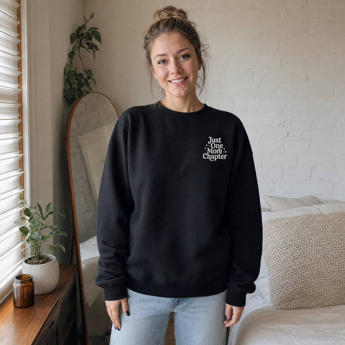 Model wearing the Just One More Chapter sweatshirt in Black, lifestyle image 1