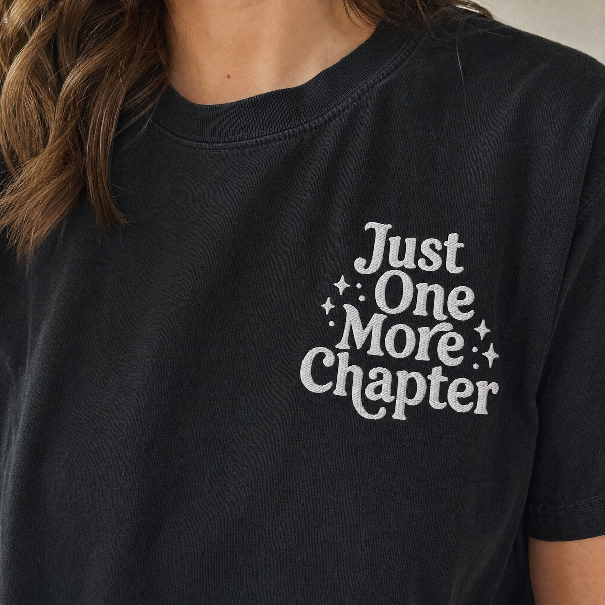 Model wearing the Just One More Chapter comfort colors tee in Black, lifestyle image 2
