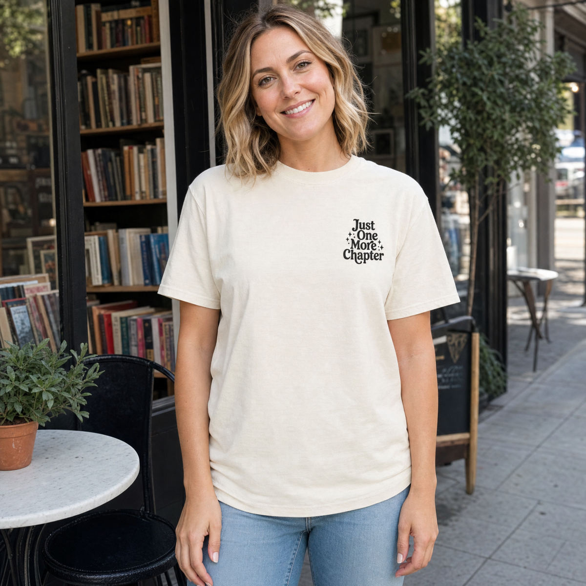Model wearing the Just One More Chapter comfort colors tee in Ivory, lifestyle image 1