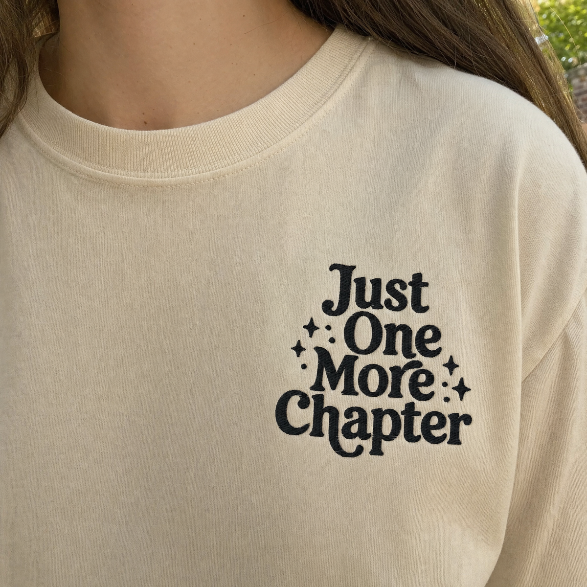 Model wearing the Just One More Chapter comfort colors tee in Ivory, lifestyle image 2