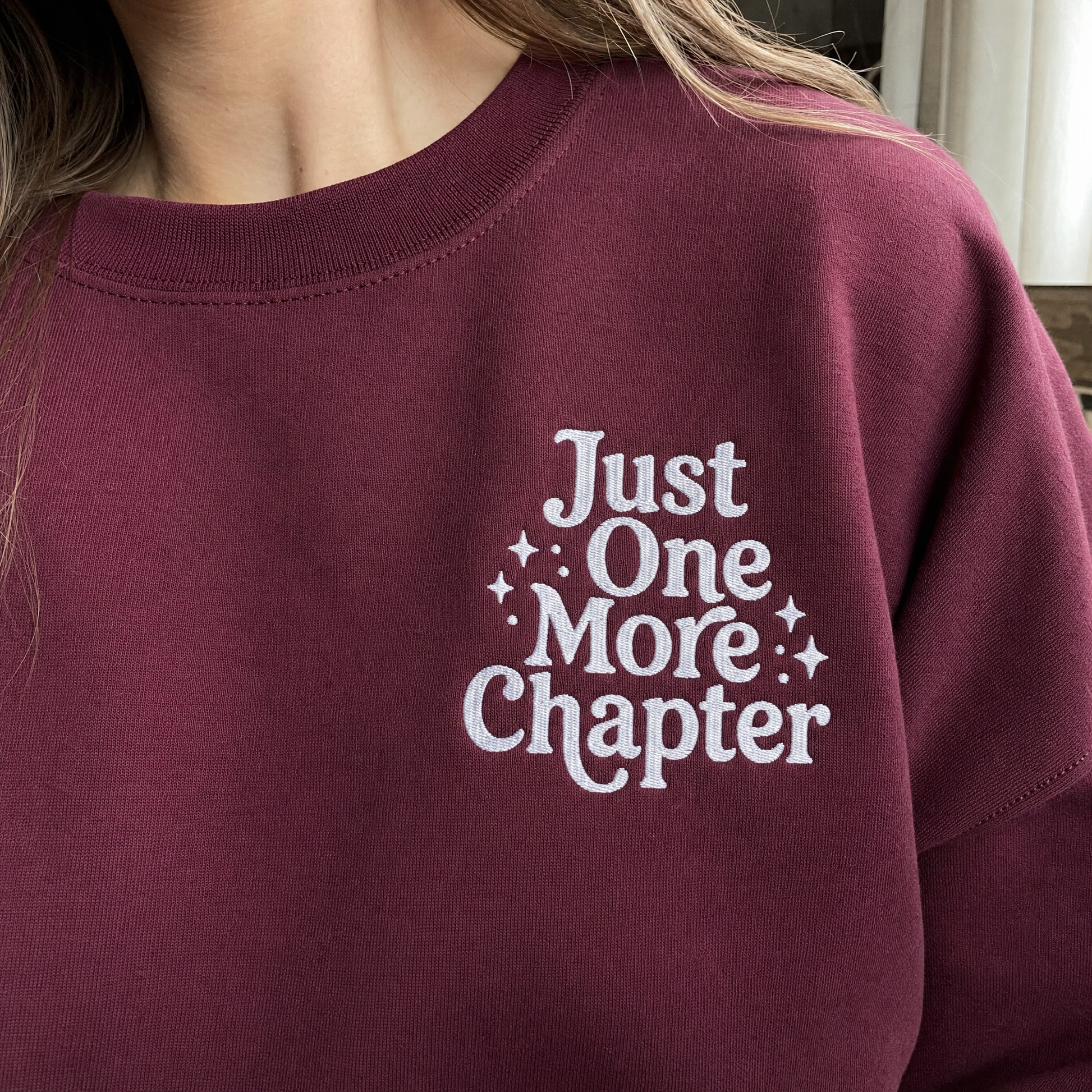 Model wearing the Just One More Chapter sweatshirt in Maroon, lifestyle image 2