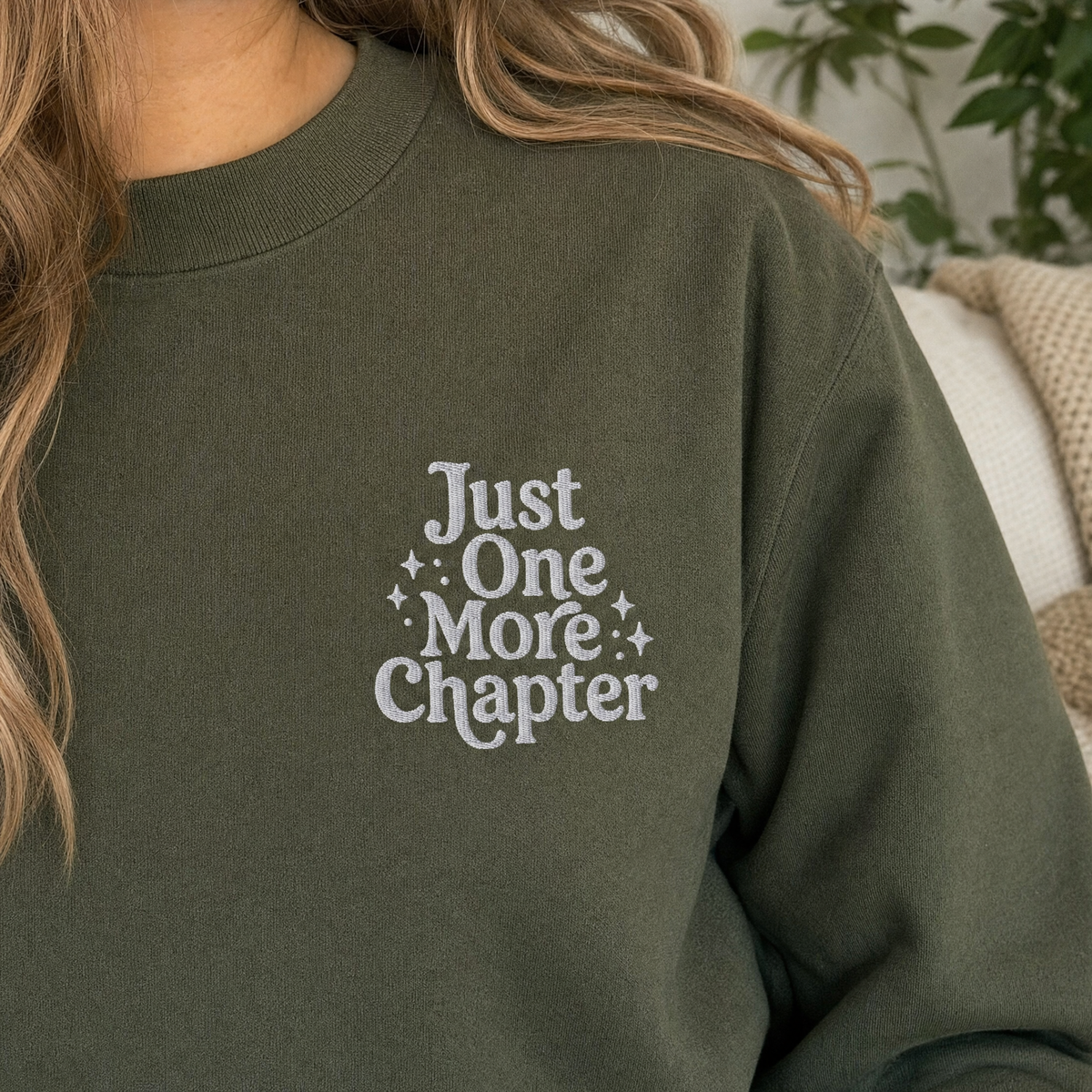 Model wearing the Just One More Chapter sweatshirt in Military Green, lifestyle image 2