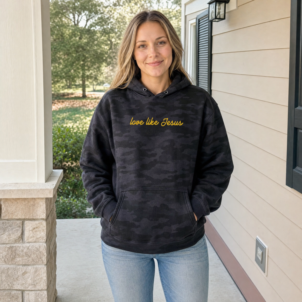 Model wearing the Love Like Jesus heavyweight hoodie in Black Camo, lifestyle image 1