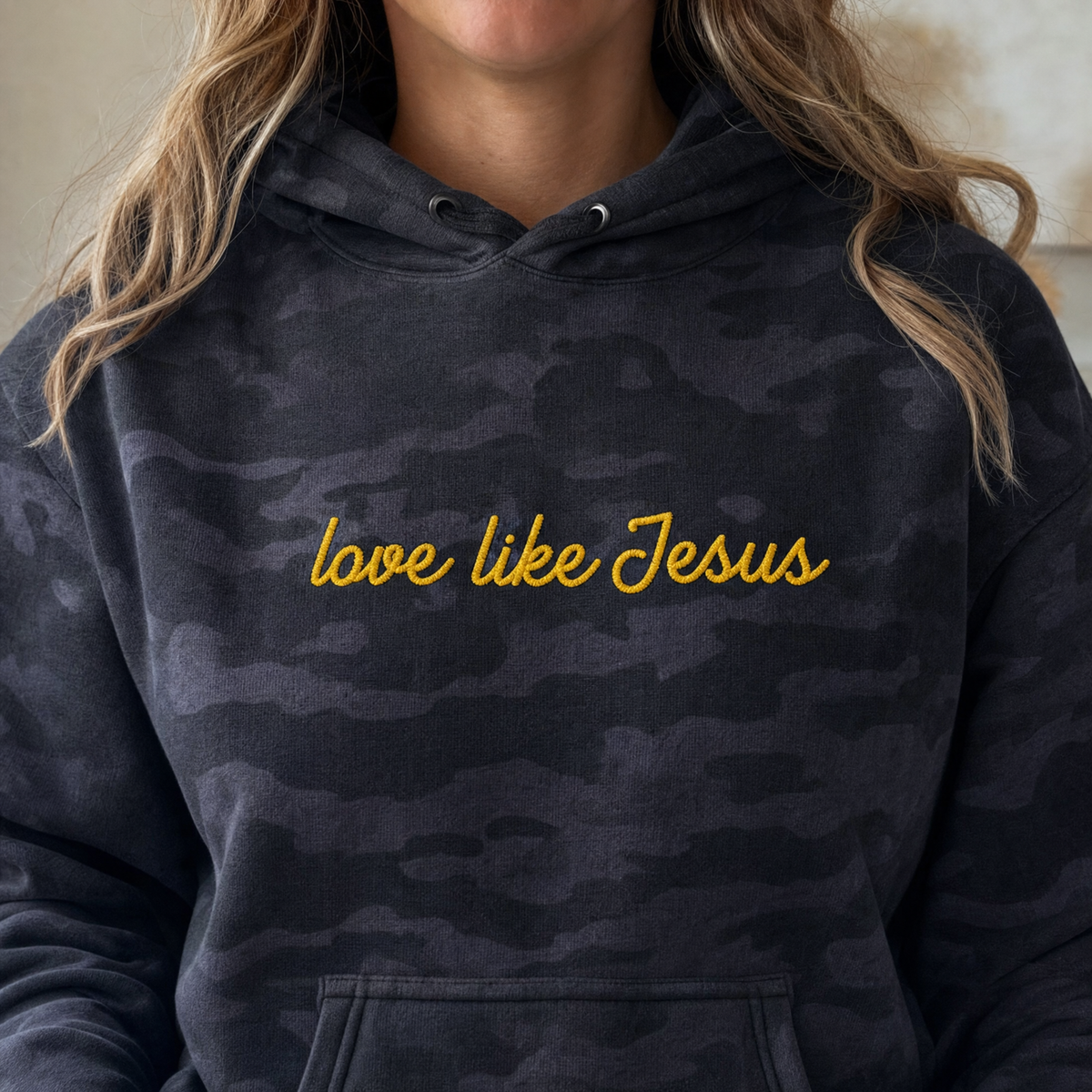 Model wearing the Love Like Jesus heavyweight hoodie in Black Camo, lifestyle image 2