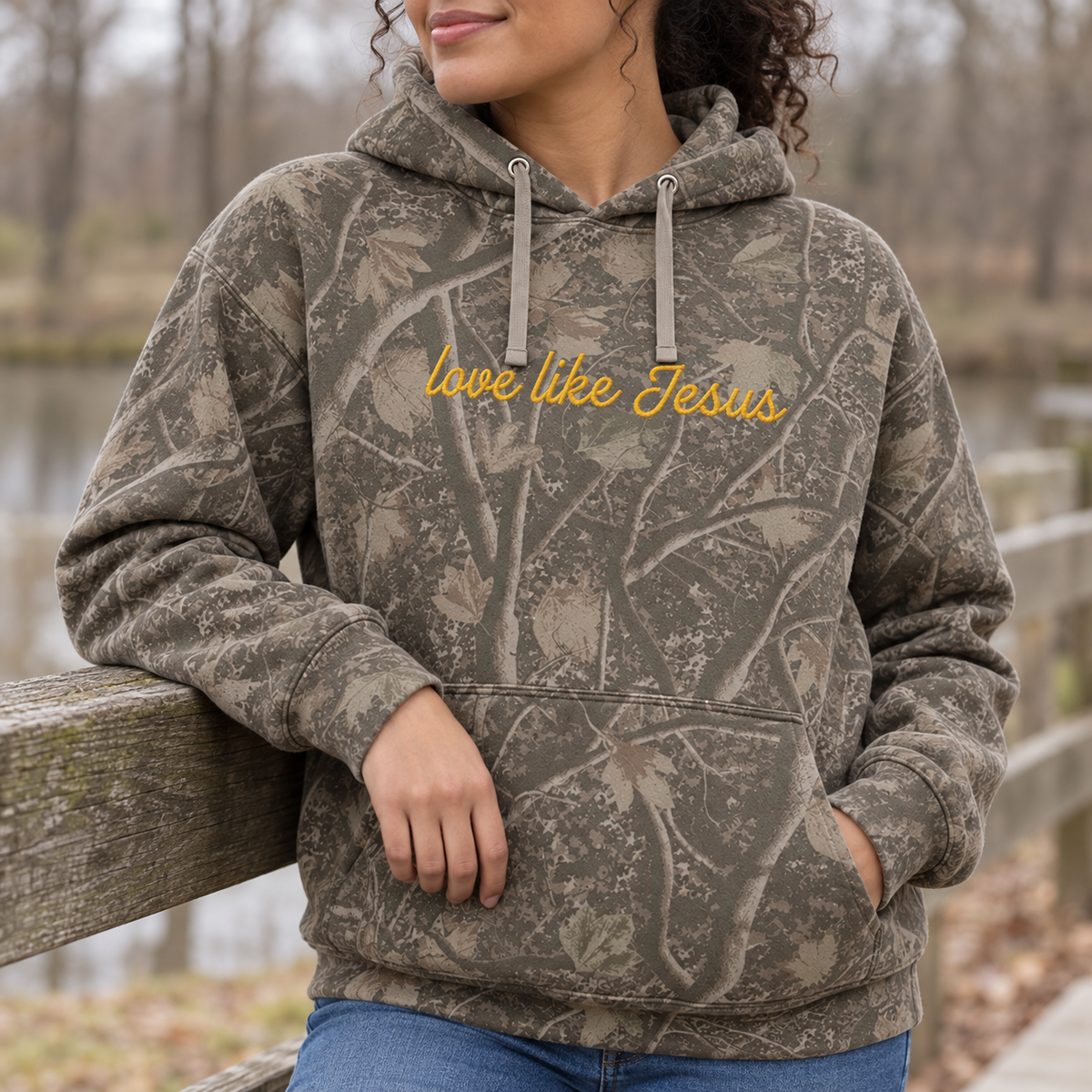 Model wearing the Love Like Jesus heavyweight hoodie in Light Tree Camo, lifestyle image 2