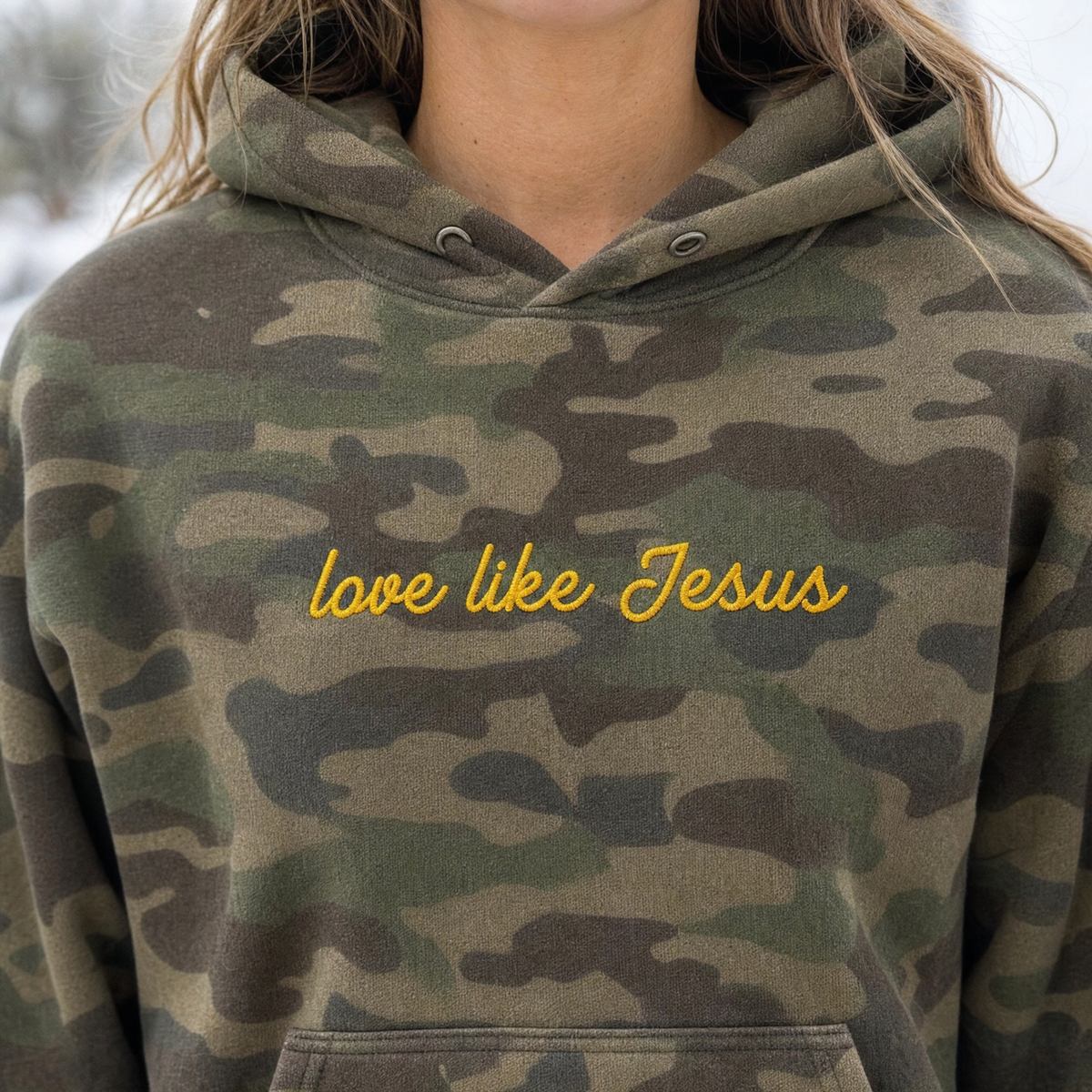 Model wearing the Love Like Jesus heavyweight hoodie in Green Camo, lifestyle image 2