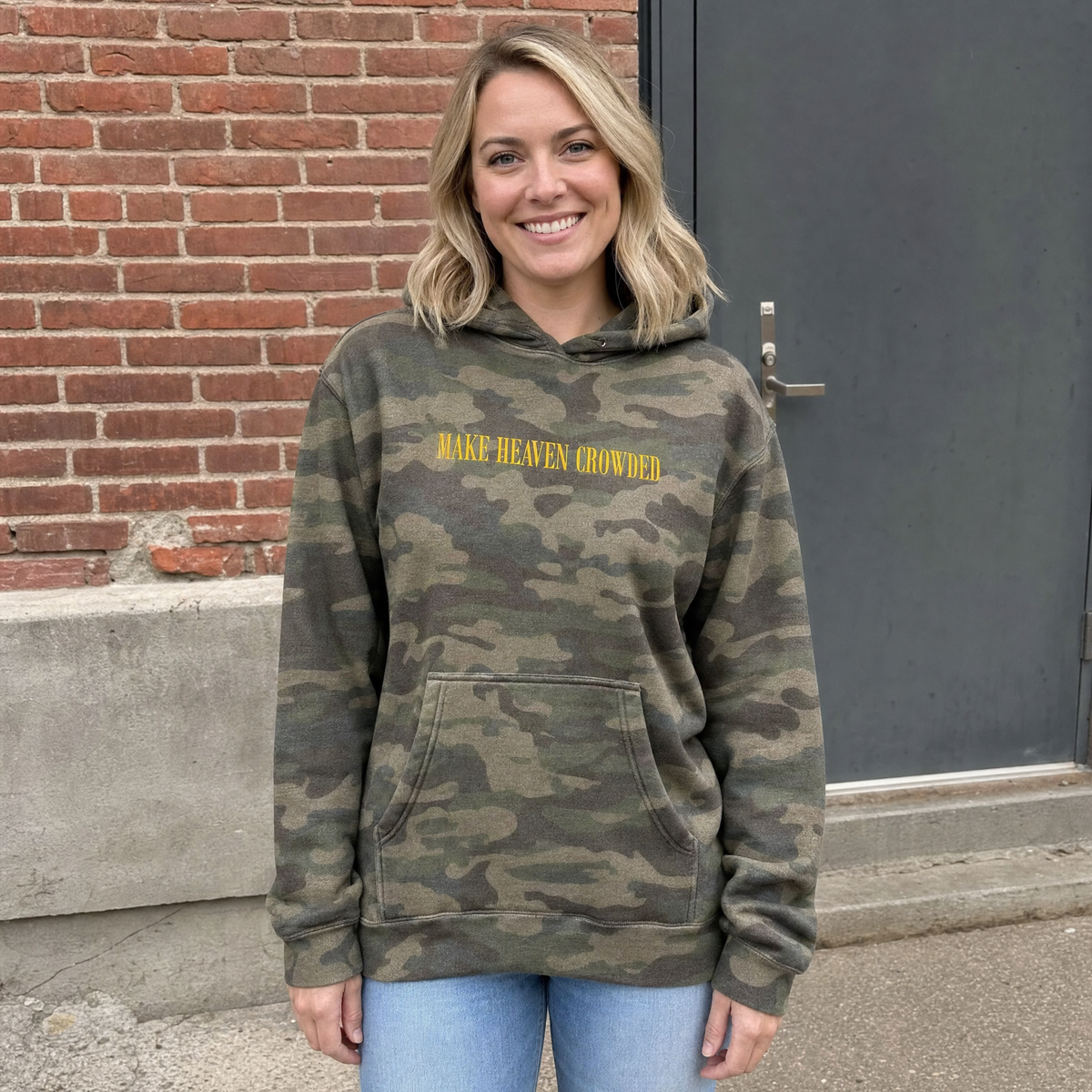 Model wearing the Make Heaven Crowded heavyweight hoodie in Green Camo, lifestyle image 1