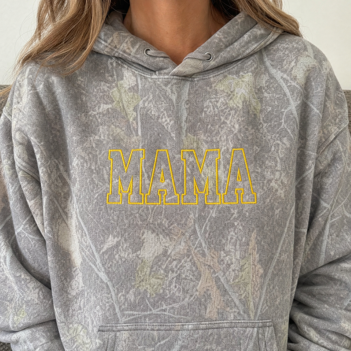 Model wearing the Mama Outline Text heavyweight hoodie in Light Tree Camo, lifestyle image 2
