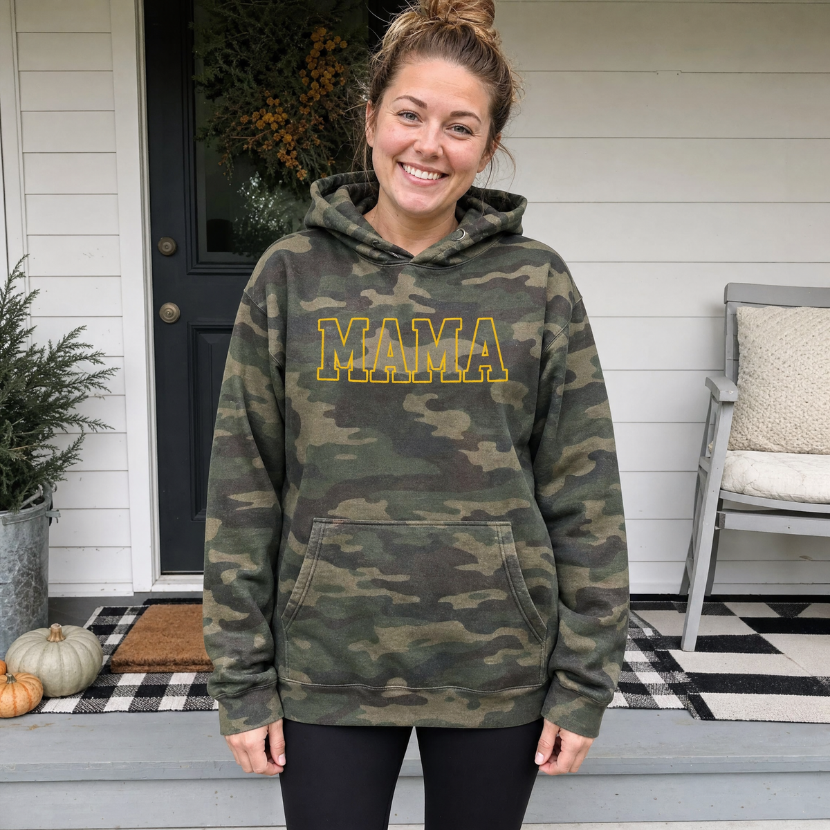 Model wearing the Mama Outline Text heavyweight hoodie in Green Camo, lifestyle image 1